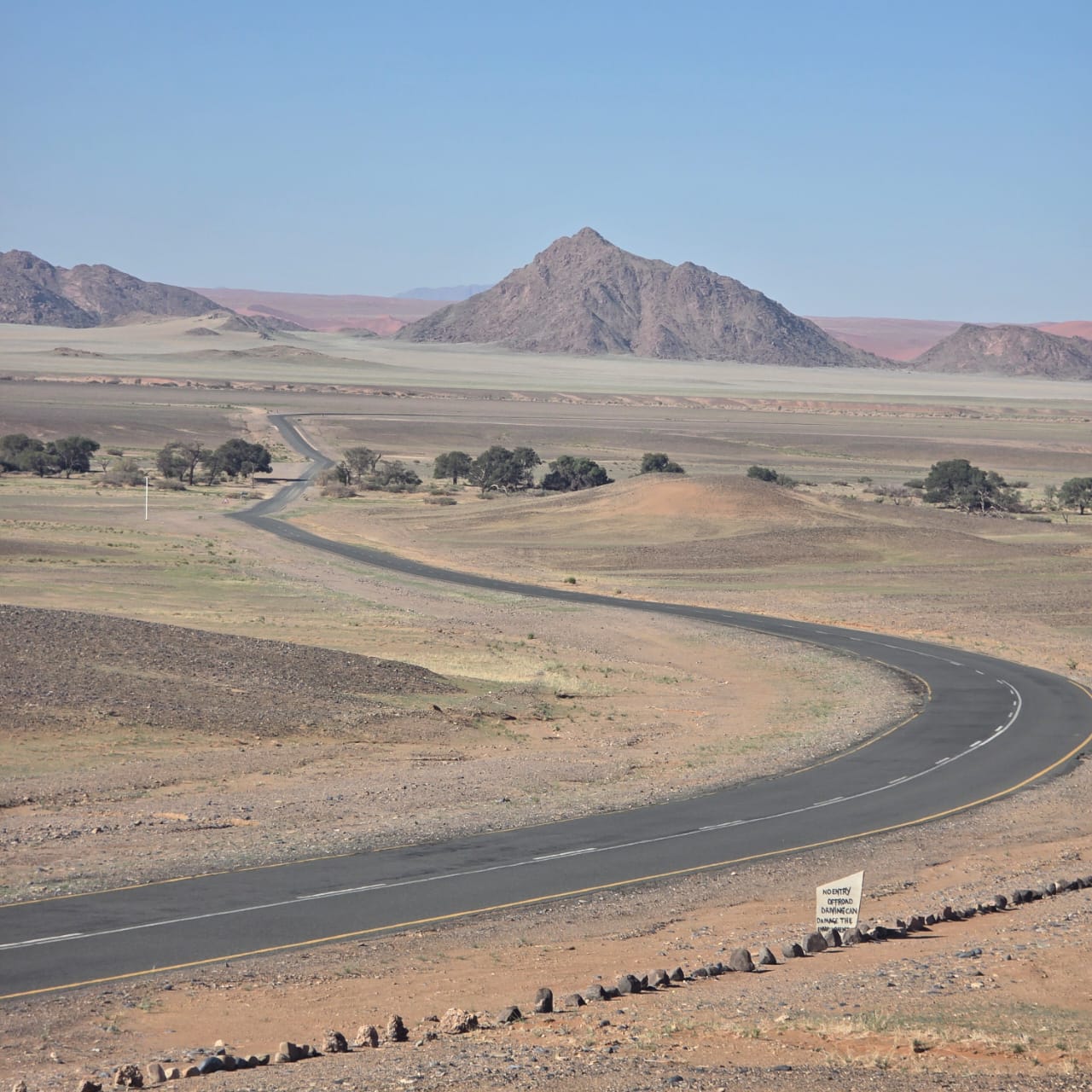 A gravel road winding through the Namib mountains